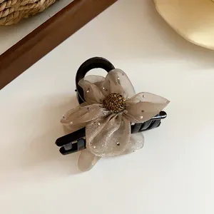 Vue détaillée de la pince à cheveux fleur en résille champagne avec centre doré