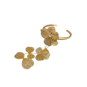 Elegant gold-tone floral open bangle featuring intricate mesh petals and a zircon accent