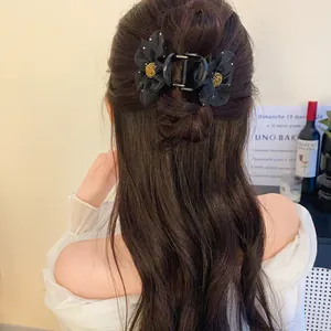 Vue arrière d'un mannequin portant une pince à cheveux en tulle noir pour un look français.