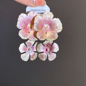 Dettaglio ravvicinato di orecchini a fiore in smalto vintage con perni argento S925