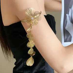 Close-up detail of an elegant gold flower armlet with zircon center and leaf tassels