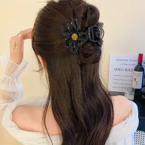 Pince à cheveux élégante avec fleur en résille noire dans une coiffure sophistiquée