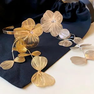 Close-up detail of elegant gold and silver flower bracelets with fine wire-drawn texture