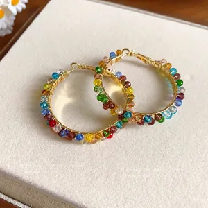 Vibrant multi-colored crystal bead wrapped gold hoop earrings featuring elegant bohemian design
