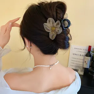 Vue macro détaillée montrant les pétales en résille de cette pince à cheveux française
