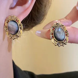 Elegant vintage oval resin stud earrings with ornate baroque gold-tone metal frame