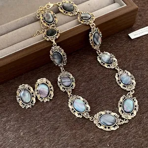 Elegant vintage gold-tone necklace and earrings set with iridescent oval resin stones