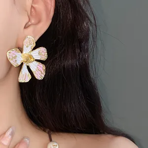 Dettaglio di orecchini a lobo vintage a fiore in smalto rosa e petali bianchi