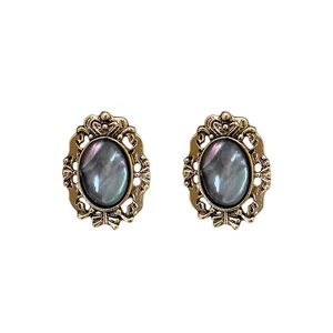 Vintage oval earrings with iridescent resin stone in ornate gold-tone frame