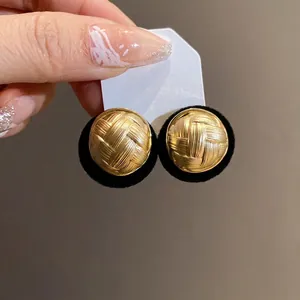 Vintage round gold stud earrings with elegant woven texture and black flocked base