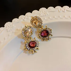 Detailed macro shot of vintage court style earrings featuring amber and purple crystals.