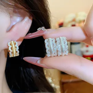 Macro shot of 18K gold and silver plated zircon hollow hoop earrings with textured detail