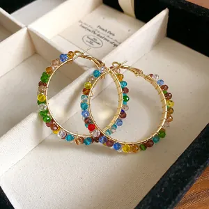 Detailed view of gold hoop earrings adorned with vibrant multicolored crystal beads