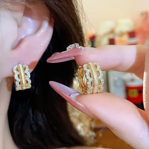 Close-up of 18K gold plated hoop earrings with hollow lattice design and pavé zircons