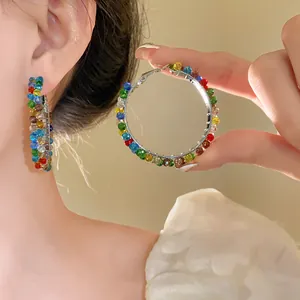 Detail of multi-colored crystal hoop earrings with faceted beads on silver frames