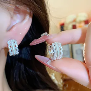 Close-up of elegant 18K gold plated zircon hollow hoop earrings for stylish women.