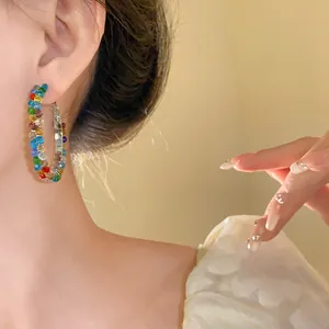 Elegant colorful crystal bead hoop earrings worn on ear, fashionable jewelry design.
