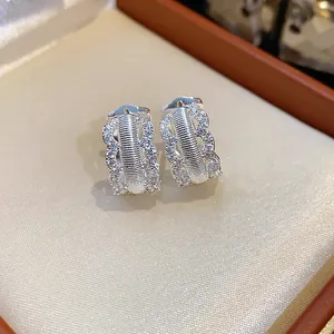 Detailed macro view of elegant hollow-out silver earrings with sparkling cubic zirconia