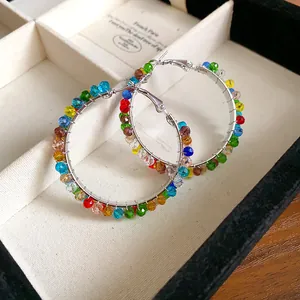 Close-up detail of colorful faceted crystal beads wrapped on elegant silver hoop earrings