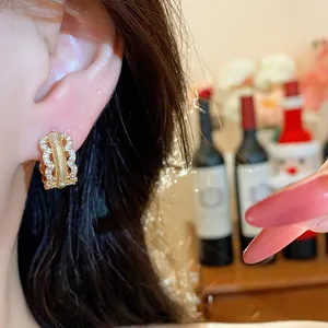 Detailed close-up showing an 18K gold-plated zircon hollow hoop earring worn on ear