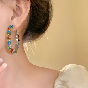 Vibrant multi-colored crystal beaded hoop earrings shown on model for fashion detail