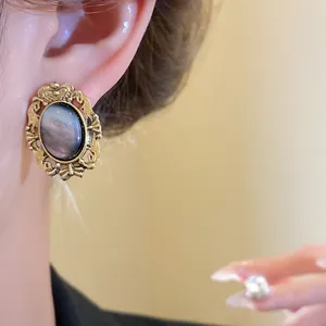 Detailed view of a vintage-style oval resin earring featuring an ornate gold frame