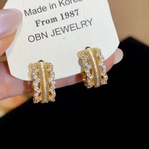 Close-up detail of 18K gold plated hollow hoop earrings with sparkling zircons.