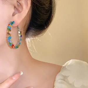 Vibrant rainbow crystal hoop earrings shown on model for an elegant and stylish look.