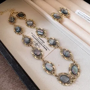 Vintage oval resin necklace and earrings set with gold-tone frames in a jewelry box