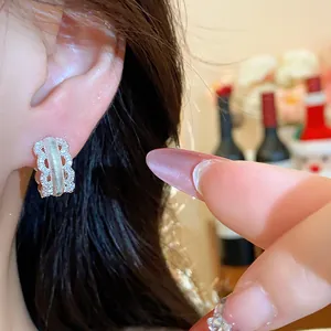 Close-up of sparkling cubic zirconia hollow hoop earring in palace style