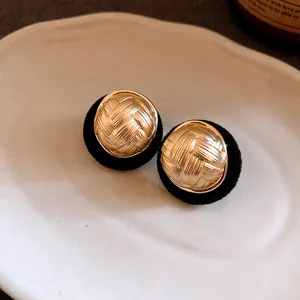 Detailed view of vintage golden textured stud earrings with elegant black flocking
