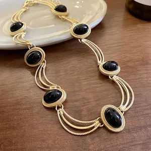 Collier vintage de style palais avec pierres noires et design géométrique ovale doré élégant