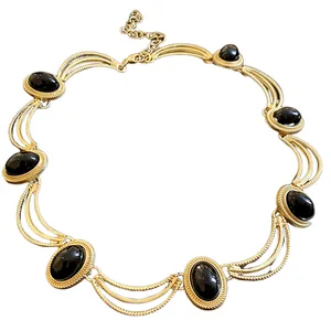 Élégant collier ras du cou vintage style palais doré avec pierres noires ovales sur fond blanc
