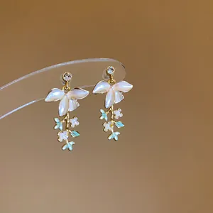 Primo piano di orecchini a ramo floreale con petali in smalto e zirconi cubici