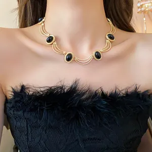 Collier ras-du-cou vintage doré avec pierres noires ovales et maillons arqués élégants
