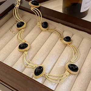 Détail d'un collier de style royal vintage avec éléments dorés et pierres ovales noires