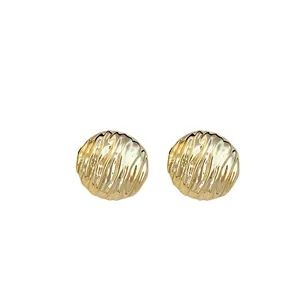 Elegant gold-toned ribbed round stud earrings with a minimalist textured metal design.