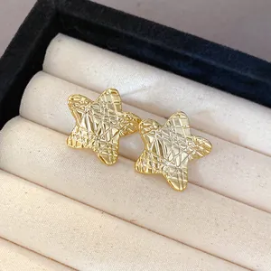 Detailed view of gold-tone star-shaped earrings with unique wrinkled texture in a display case.