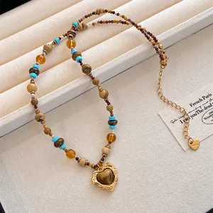 Vue détaillée d'un collier de perles ethniques avec pendentif en pierre d'œil de tigre