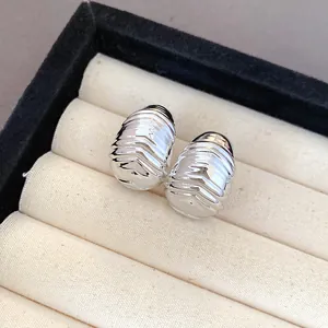 Macro view of silver-tone textured water-drop earrings in a jewelry box