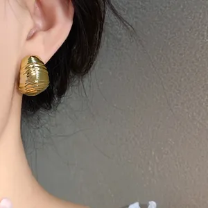 Close-up detail of a gold pleated waterdrop earring featuring an elegant wrinkled texture