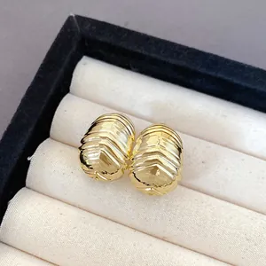 Close-up detail of luxury gold pleated ribbed teardrop stud earrings in a display box