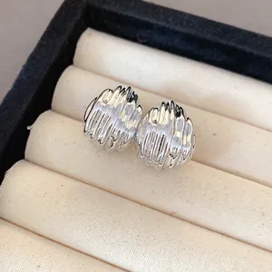 Close-up of silver rippled teardrop stud earrings with textured finish in a jewelry box.