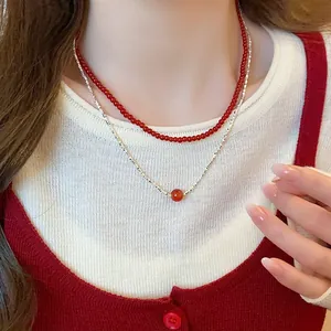 Detailed view of an elegant double-layered red agate necklace worn on a model's neck