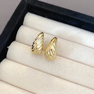 Close-up detail of elegant gold-toned pleated ribbed water-drop earrings in a display box