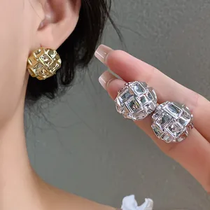 Close-up of gold and silver textured stud earrings showing the crinkled square pattern.