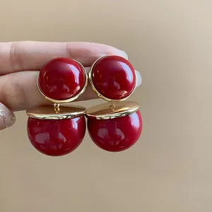 Close-up view of vintage-style red and gold bold spherical stud earrings for women