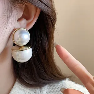 Elegant retro double pearl stud earrings with gold-tone finish shown on a model