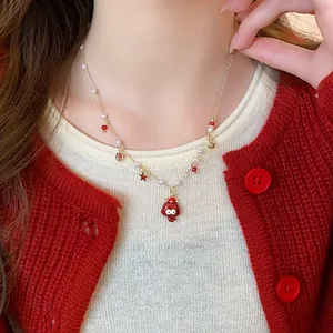 Detail view of a red agate necklace with pearl accents and festive pendants.