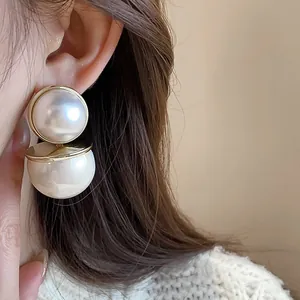 Elegant close-up of vintage double pearl drop earrings with gold trim on model ear